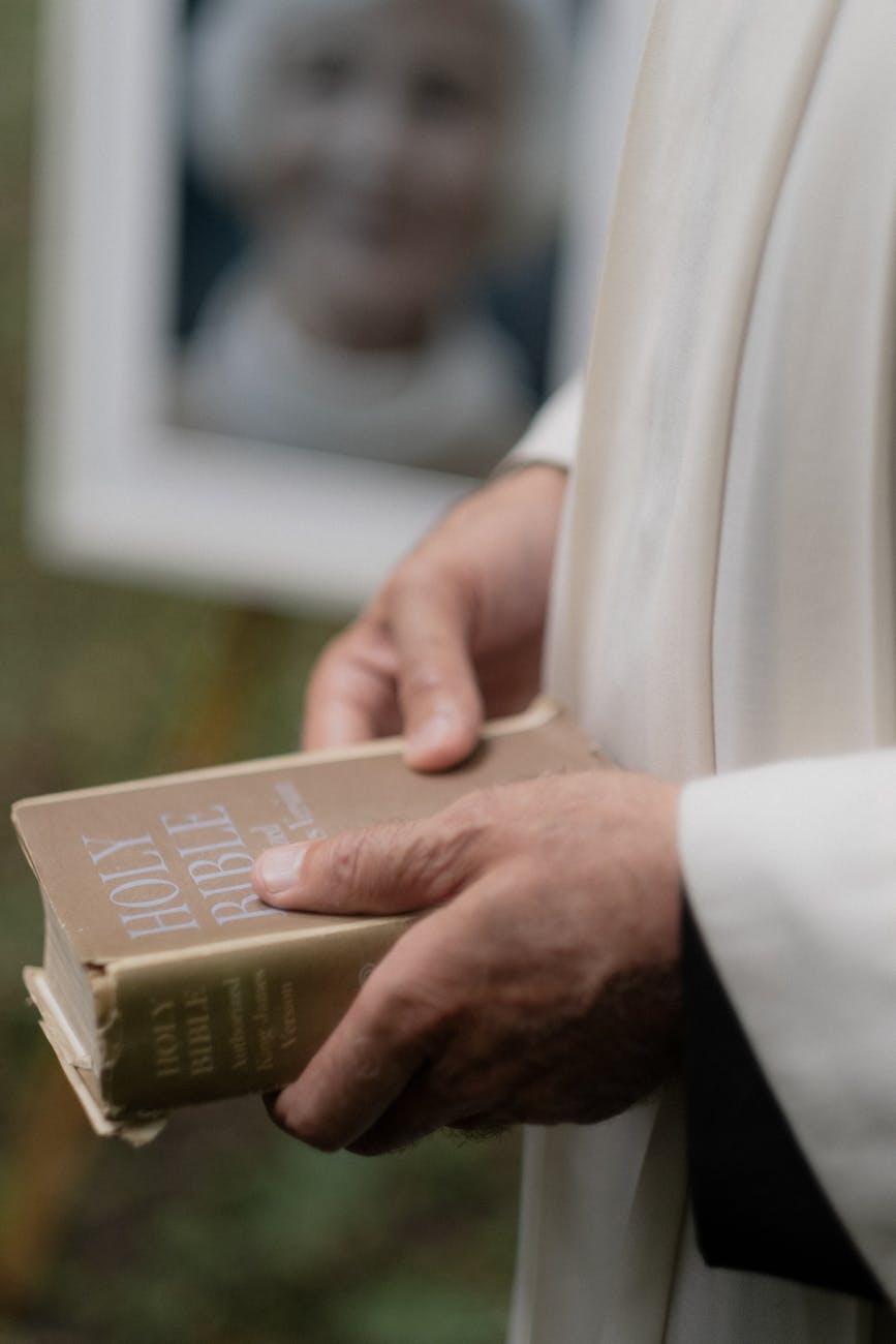 person holding a holy bible on the funeral